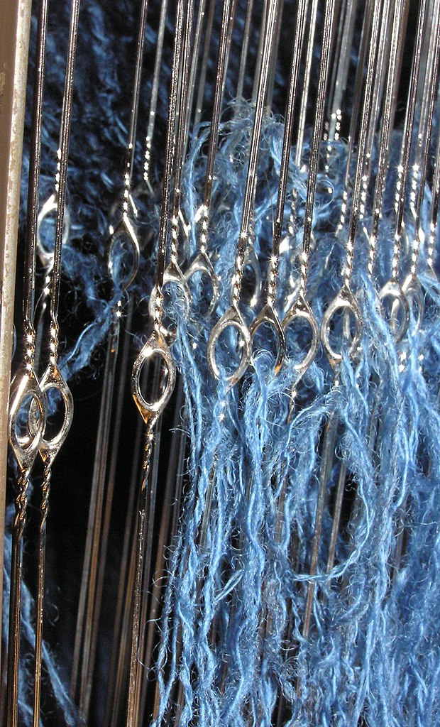 Close up of inserted eye wire heddles with blue thread